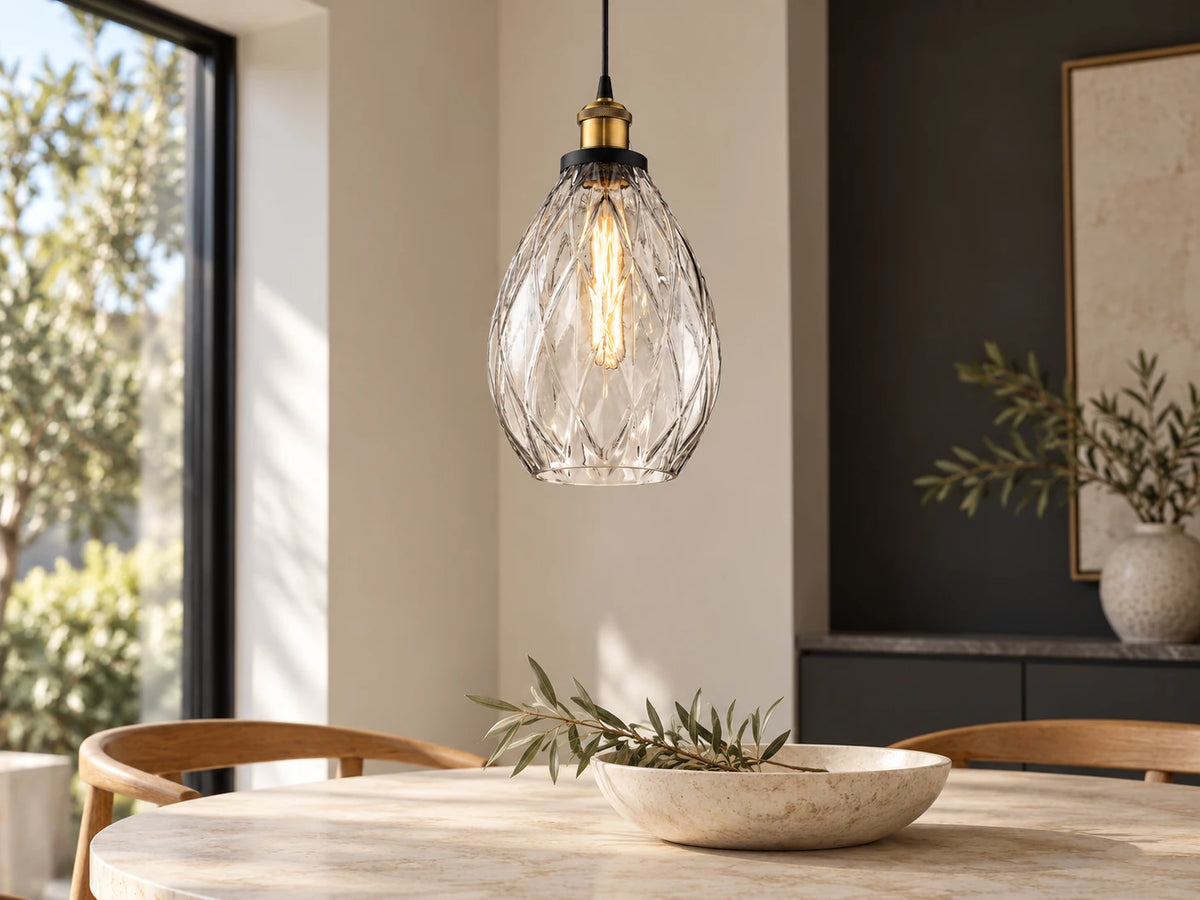 Modern interior with a clear glass Domus EVELYN pendant above a limestone table